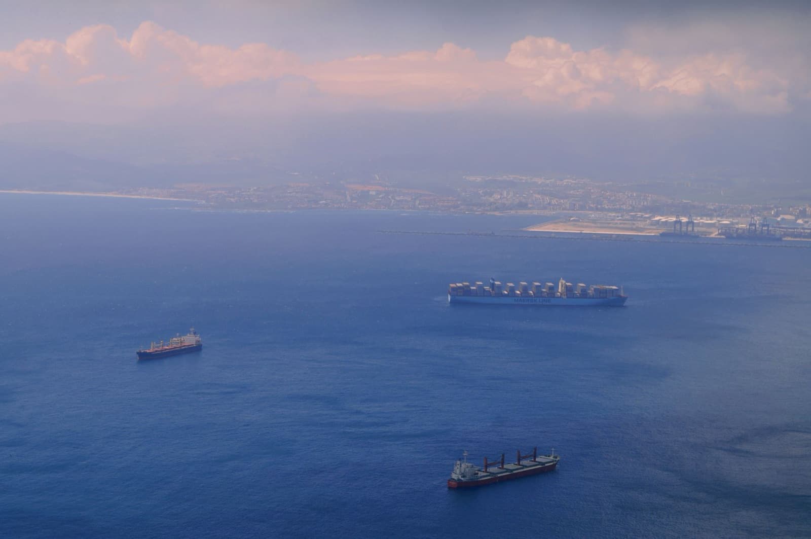 Aerial view of cargo ships anchored off a coastline